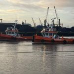 two orange and white John McLoughlin tug boats on the water